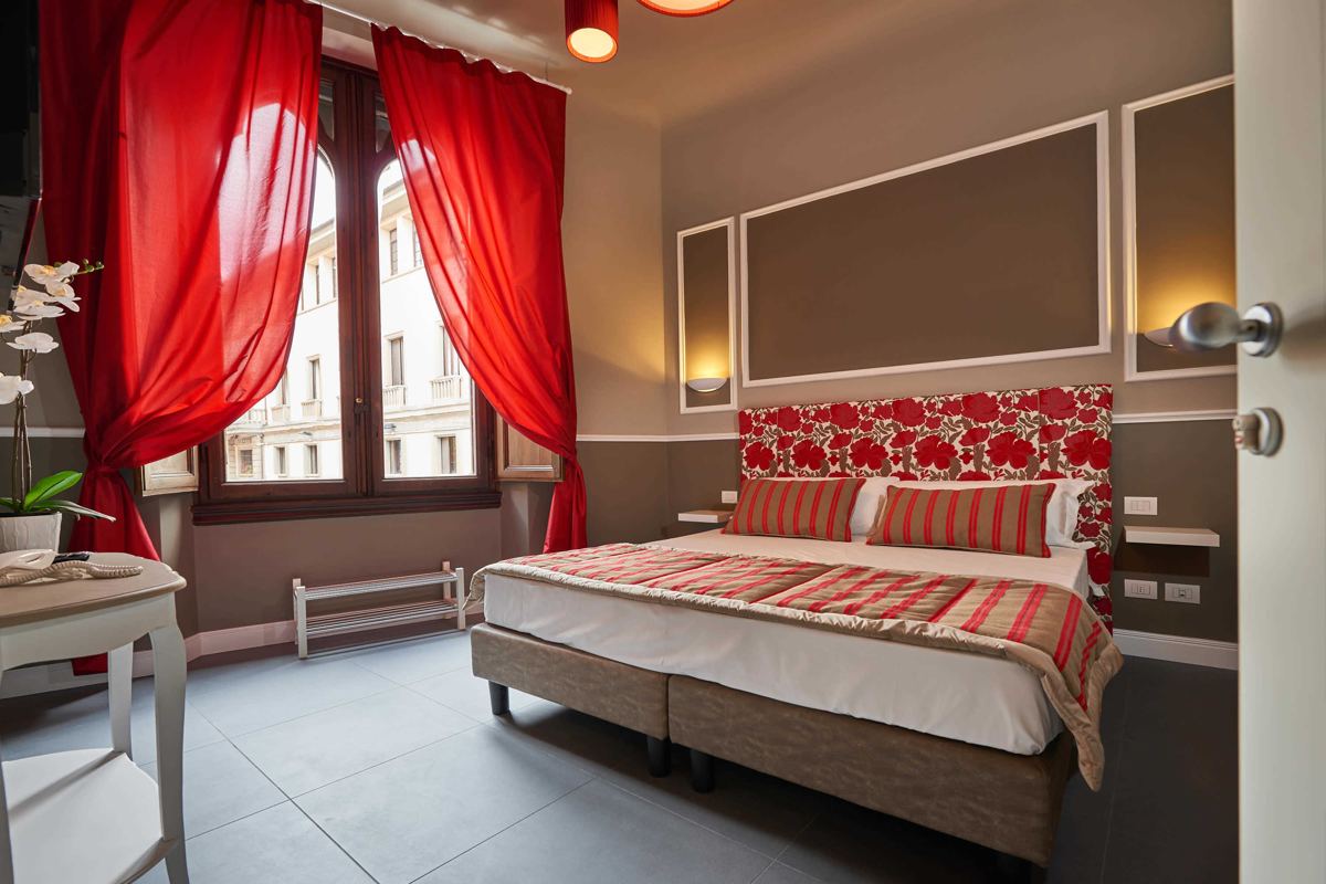 Habitación Premium con cabecero rojo y cortinas rojas