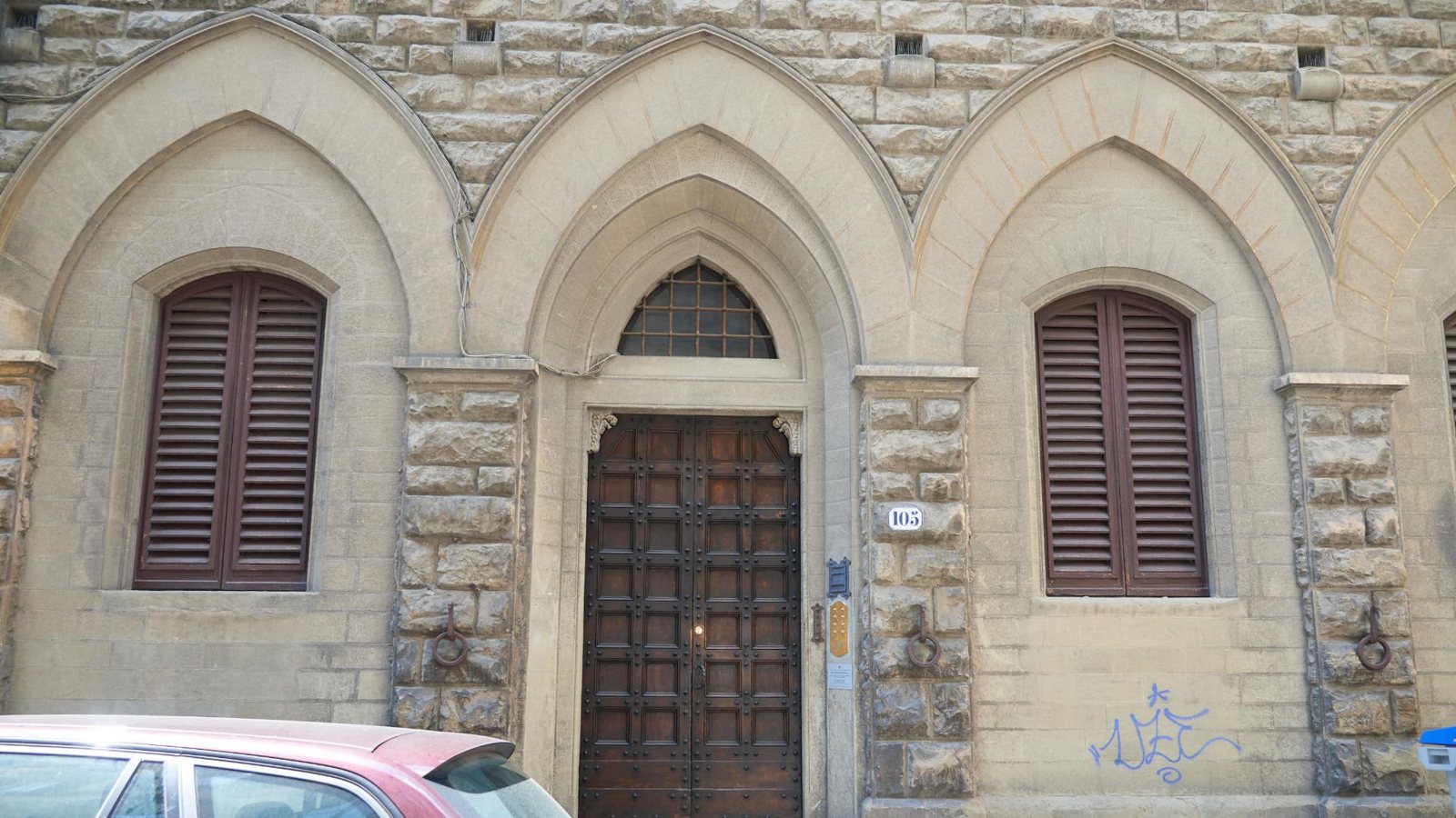 Il portone in pietra del palazzo con le bifore